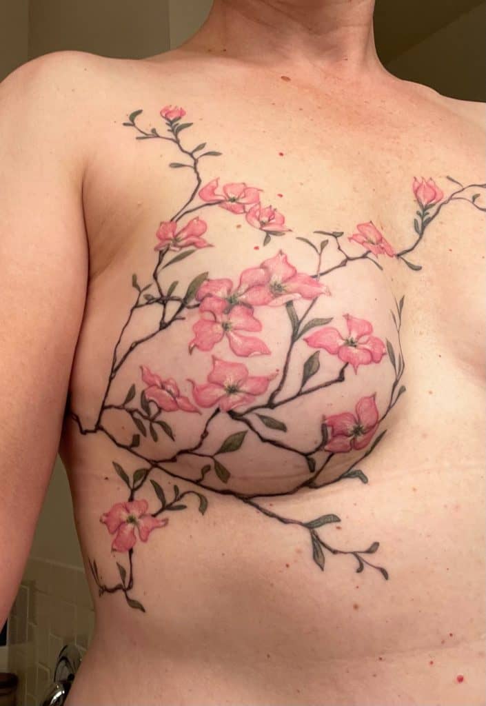 Pink flowers and vines tattooed over breast with no nipple due to cancer