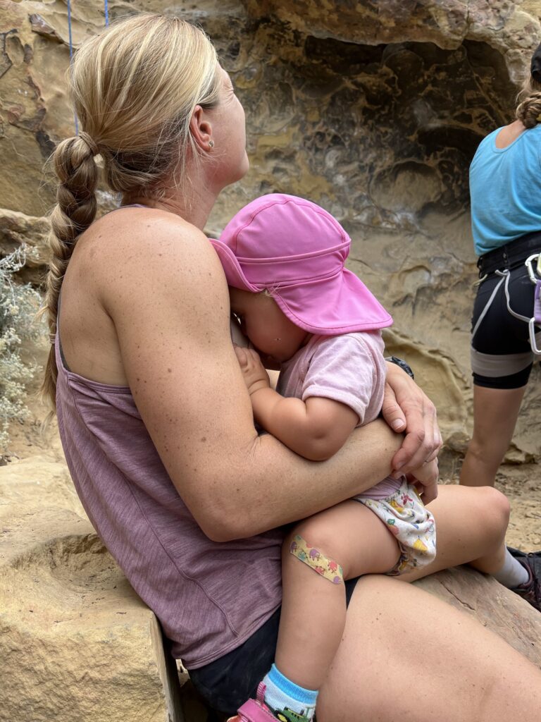 Mom rock climbing and breastfeeding